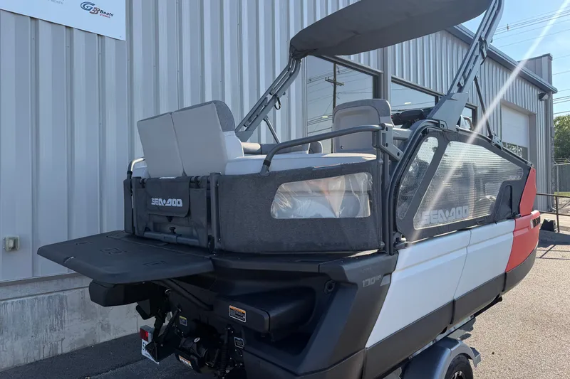 Slide: The Image of 2024 Sea-Doo Switch Compact boat, rear view, parked outside a metal building. - 13