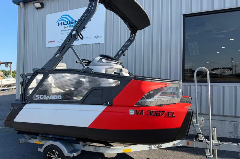 Slide: The Image of 2024 Sea-Doo Switch Compact on trailer, parked outside a marine service center. - 2