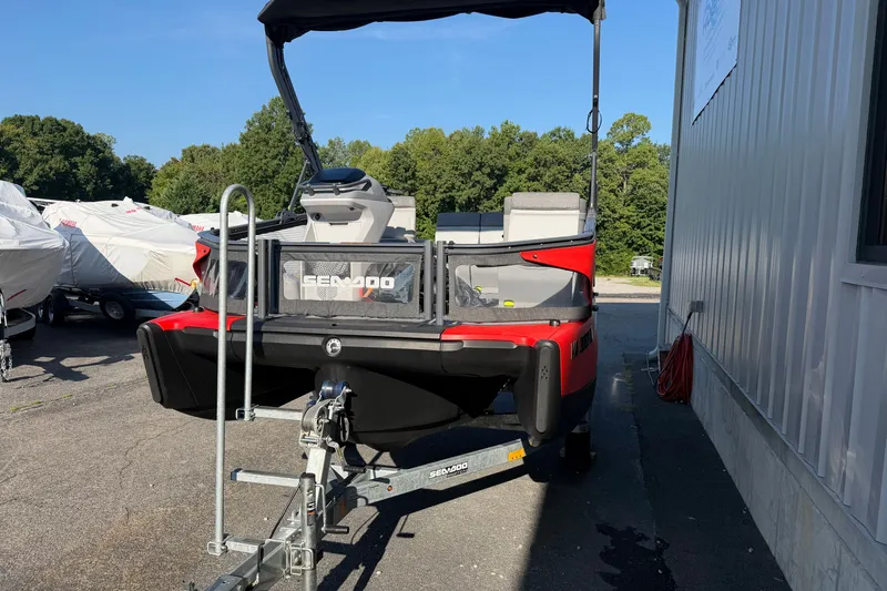 Slide: The Image of 2024 Sea-Doo Switch Compact on trailer, parked outdoors near covered boats. - 18