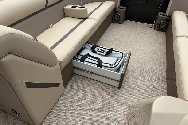 Slide: The Image of 2023 Crest Classic LX 240 SLSC boat interior with beige seating and storage drawer. - 17