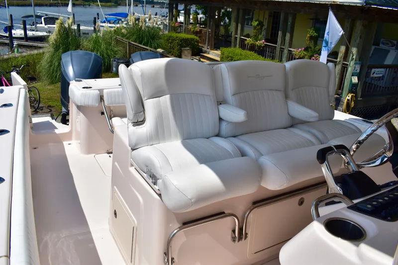 Slide: The Image of 2013 Grady-White Canyon 336 boat with plush white seating and dual engines at a marina. - 66