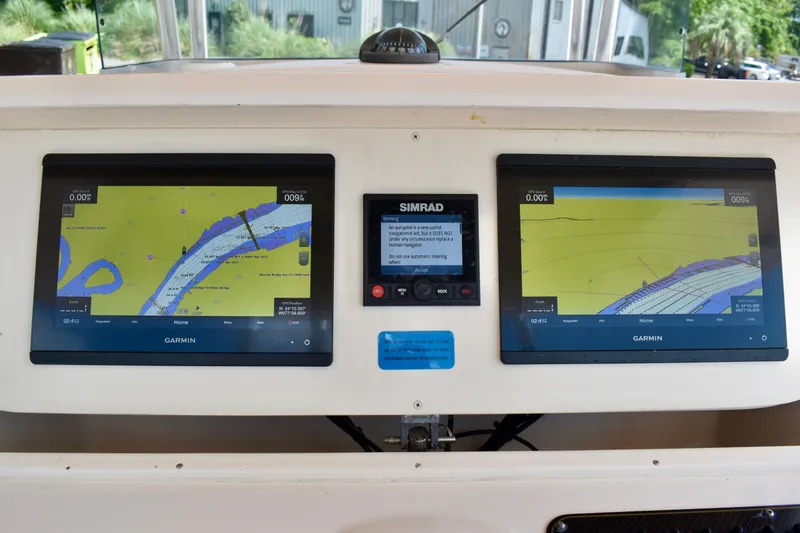 Slide: The Image of Garmin navigation screens on a 2013 Grady-White Canyon 336 boat dashboard. - 73