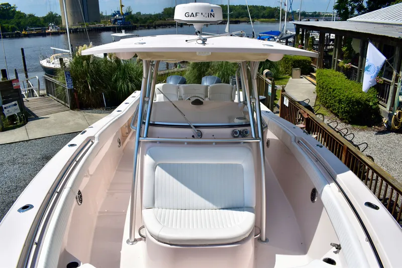 Slide: The Image of 2013 Grady-White Canyon 336 boat docked at a marina, showcasing spacious seating and sleek design. - 63