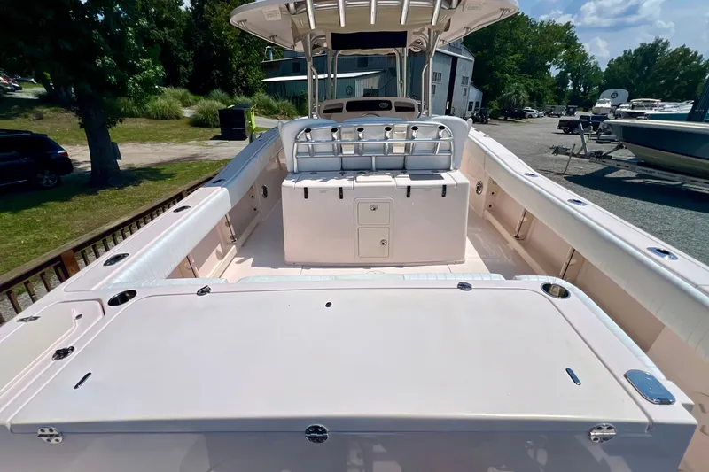 Slide: The Image of 2013 Grady-White Canyon 336 boat interior with seating and storage, docked outdoors. - 26