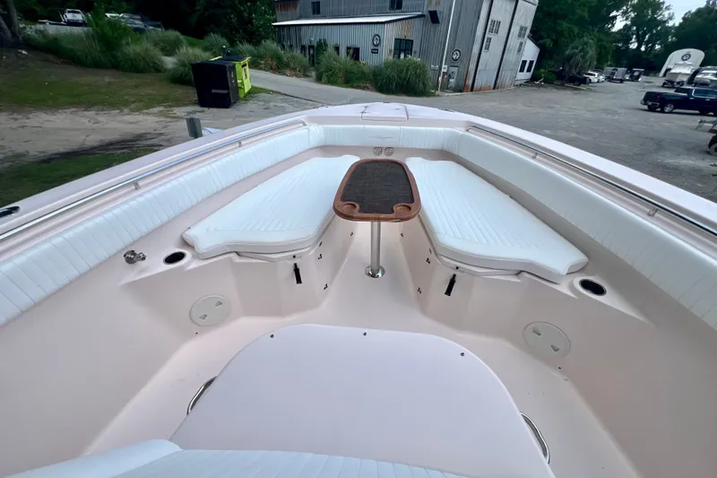 Slide: The Image of 2013 Grady-White Canyon 336 boat interior with seating and table, docked outdoors. - 44