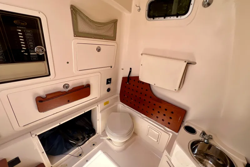 Slide: The Image of 2013 Grady-White Canyon 336 boat interior with toilet, sink, and storage compartments. - 34