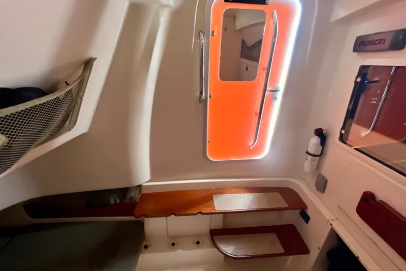 Slide: The Image of 2013 Grady-White Canyon 336 cabin interior with wooden shelves and orange-lit door. - 32