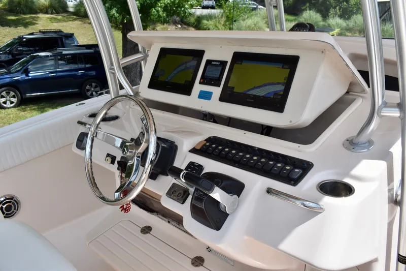 Slide: The Image of 2013 Grady-White Canyon 336 boat dashboard with dual navigation screens and steering wheel. - 71