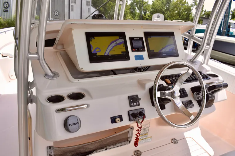 Slide: The Image of 2013 Grady-White Canyon 336 boat dashboard with navigation screens and steering wheel. - 72