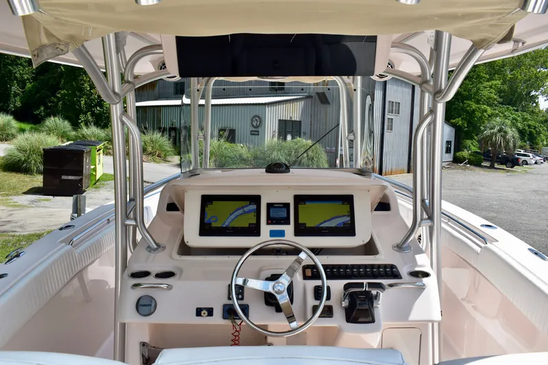 Slide: The Image of 2013 Grady-White Canyon 336 boat cockpit with navigation screens and steering wheel. - 69