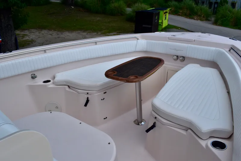 Slide: The Image of 2013 Grady-White Canyon 336 boat interior with cushioned seating and a wooden table. - 21