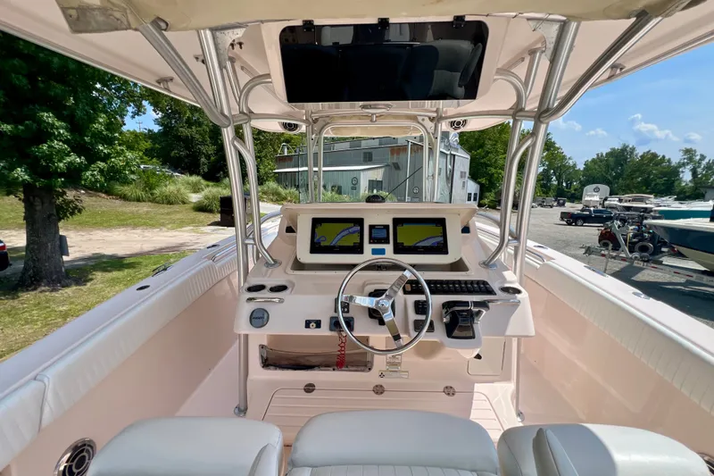 Slide: The Image of 2013 Grady-White Canyon 336 boat cockpit with steering wheel and navigation screens. - 43