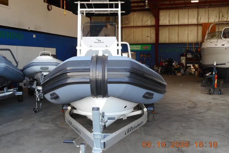 Slide: The Image of Highfield Patrol 540 boat on trailer in indoor storage, 2025 model. - 2