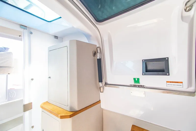 Slide: The Image of Interior of 2025 Axopar 37 Sun-Top boat, featuring modern design and storage cabinet. - 36