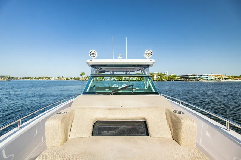 Slide: The Image of 2025 Axopar 37 Sun-Top boat on calm water, clear sky background. - 25