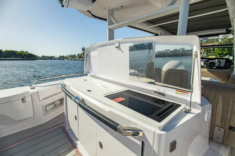 Slide: The Image of 2025 Axopar 37 Sun-Top boat with outdoor kitchen, scenic water view. - 18