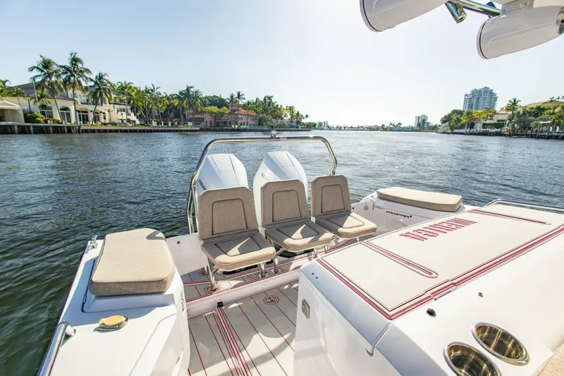 Slide: The Image of 2025 Axopar 37 Sun-Top boat with seating, cruising on a scenic waterway. - 24