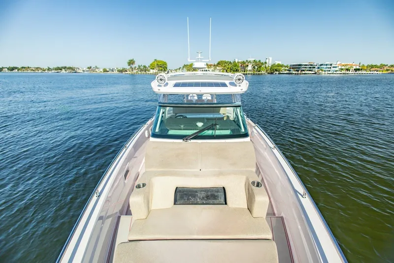 Slide: The Image of 2025 Axopar 37 Sun-Top boat cruising on a serene lake under clear blue skies. - 40