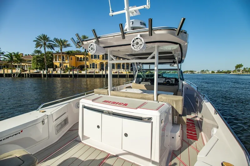 Slide: The Image of 2025 Axopar 37 Sun-Top boat on water, featuring spacious deck and luxurious seating. - 16