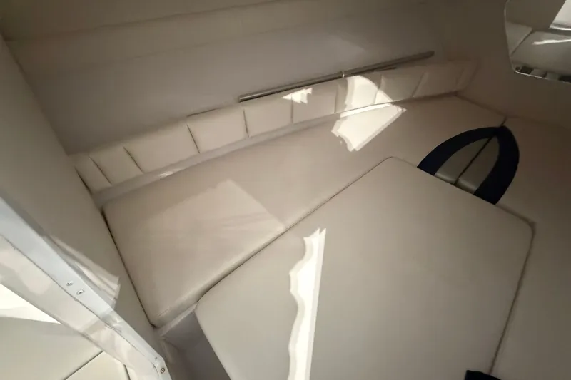 Slide: The Image of Interior of 2007 Donzi 29 ZF Cuddy boat, featuring white cushioned seating. - 18