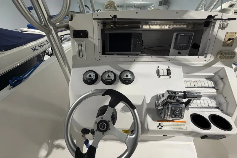 Slide: The Image of 2007 Donzi 29 ZF Cuddy boat dashboard with steering wheel and control panel. - 14