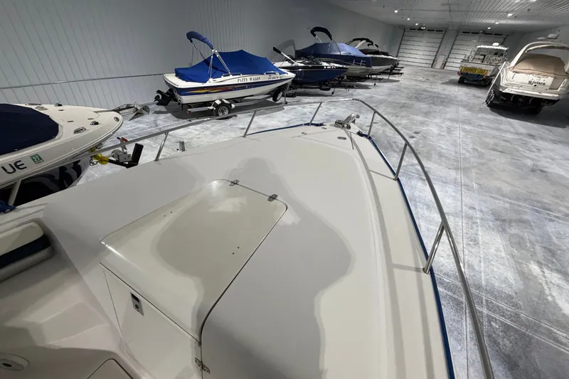 Slide: The Image of 2007 Donzi 29 ZF Cuddy boat in indoor storage with other covered boats. - 21