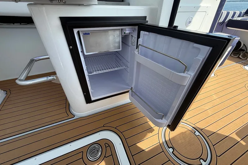 Slide: The Image of Open mini fridge on 2026 Steiger Craft 28 Annapolis boat with teak flooring. - 26