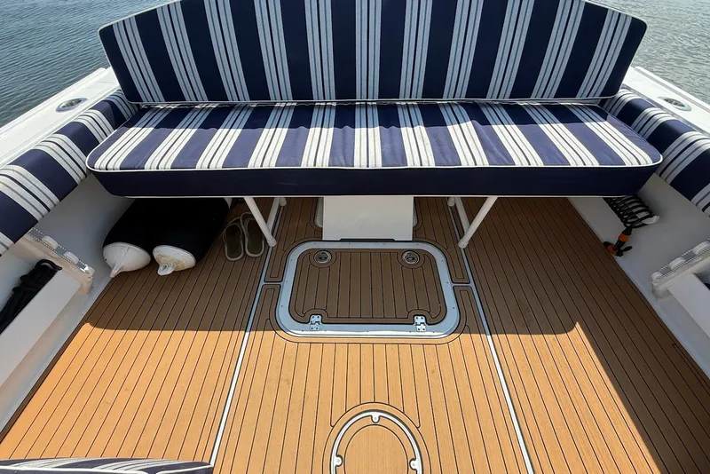 Slide: The Image of Steiger Craft 28 Annapolis 2026 boat interior with striped seating and teak flooring. - 17