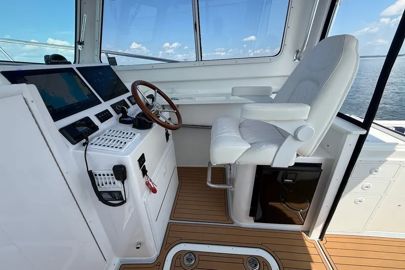 Slide: The Image of Steiger Craft 28 Annapolis 2026 helm with modern controls and luxurious captain's chair. - 25
