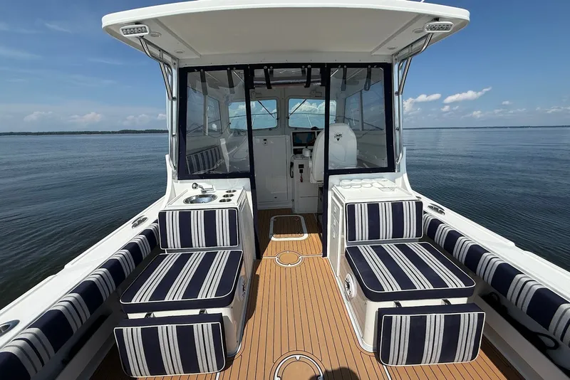 Slide: The Image of 2026 Steiger Craft 28 Annapolis boat interior with striped seating on calm water. - 15