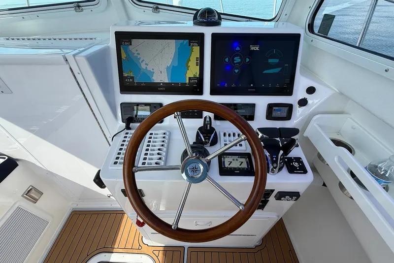 Slide: The Image of Steiger Craft 28 Annapolis 2026 helm with dual displays and wooden steering wheel. - 30