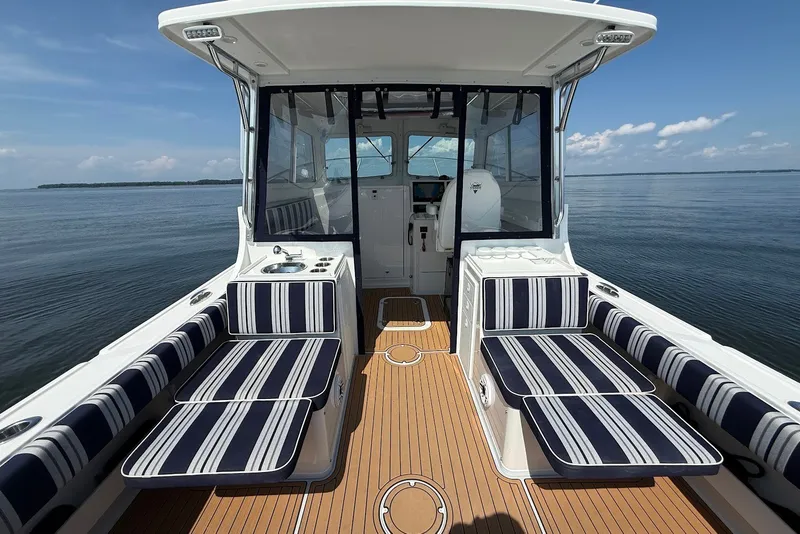 Slide: The Image of 2026 Steiger Craft 28 Annapolis boat interior with striped seating and wooden deck. - 16