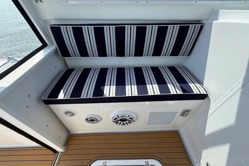 Slide: The Image of 2026 Steiger Craft 28 Annapolis interior with striped seating and teak flooring. - 24