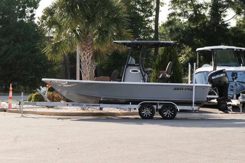 The Image of 2027 Sea Pro 230 Bay boat on trailer, parked near palm tree. - 1