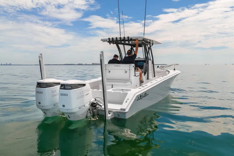 Slide: The Image of 2024 SeaHunter 28 Floridian boat with dual Suzuki engines on calm water. - 6