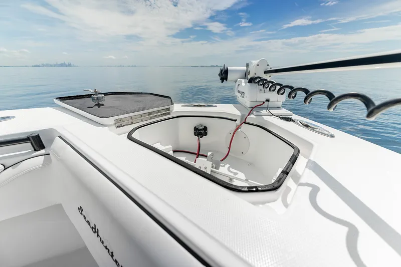 Slide: The Image of 2024 SeaHunter 28 Floridian boat deck with open storage compartments and fishing equipment. - 25