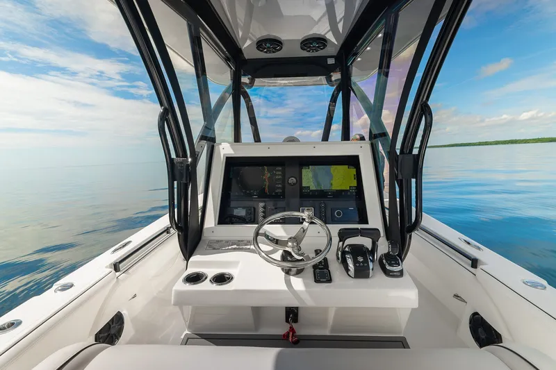 Slide: The Image of 2024 SeaHunter 28 Floridian boat cockpit with modern navigation system on calm waters. - 14