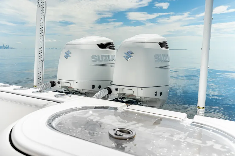 Slide: The Image of 2024 SeaHunter 28 Floridian boat with twin Suzuki outboard motors on calm water. - 19