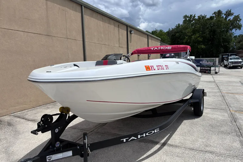 The Image of 2024 Tahoe T18 boat on trailer, parked outdoors with red canopy. - 0