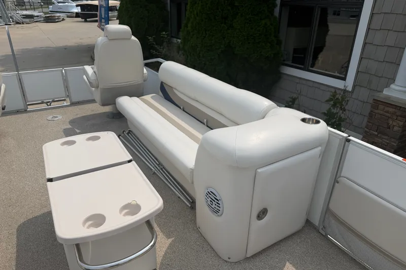 Slide: The Image of 2008 Crest 25 II XRS boat interior with white seating and table, docked outdoors. - 12