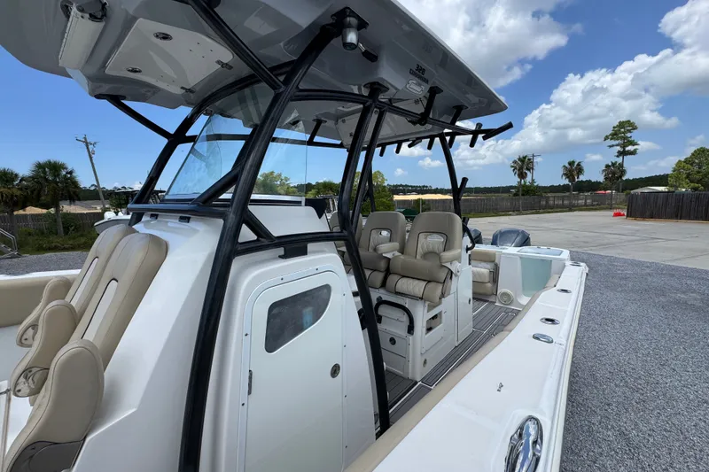 Slide: The Image of 2017 Sea Fox 328 Commander boat with seating and console, parked outdoors under a blue sky. - 27