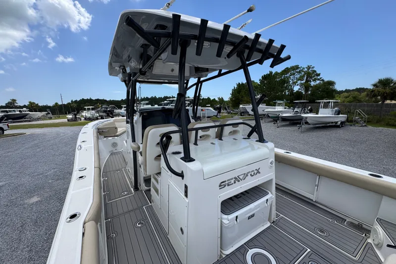 Slide: The Image of 2017 Sea Fox 328 Commander boat with spacious deck and seating, parked outdoors. - 43