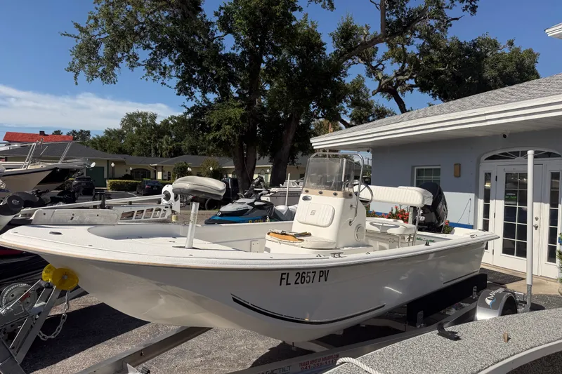 Slide: The Image of 2011 Carolina Skiff JVX18CC boat on trailer, parked near a building. - 1