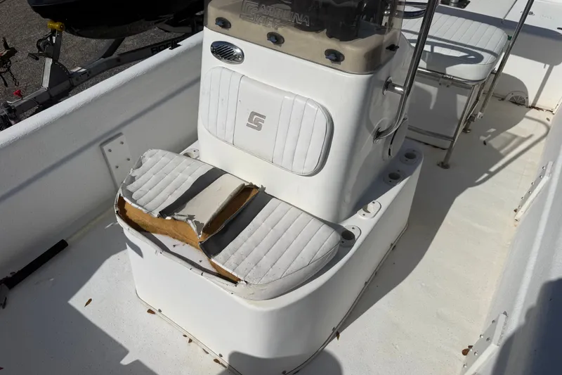 Slide: The Image of 2011 Carolina Skiff JVX18CC boat interior with worn seating and console. - 17