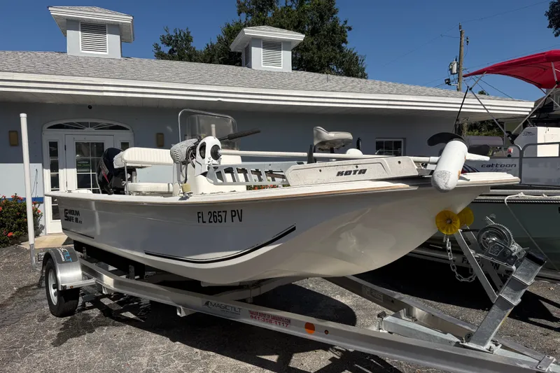 The Image of 2011 Carolina Skiff JVX18CC boat on trailer, parked outside a building. - 0