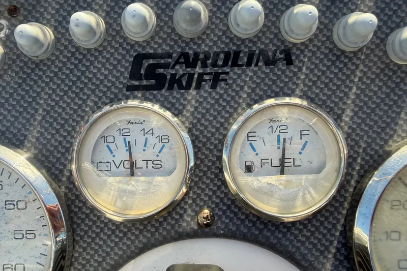Slide: The Image of Dashboard of a 2011 Carolina Skiff JVX18CC with volt and fuel gauges. - 15