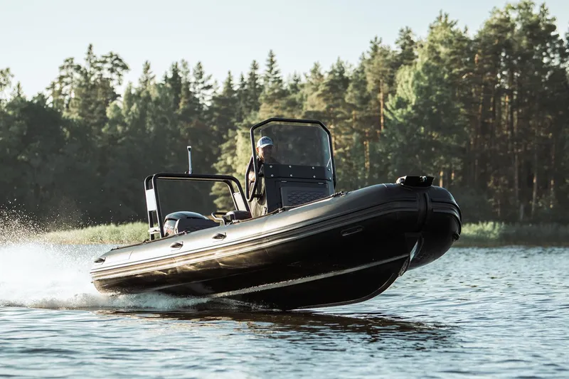 The Image of Manufacturer Provided Image: 2025 Highfield Patrol 540 boat cruising on a lake with forest backdrop. - 9