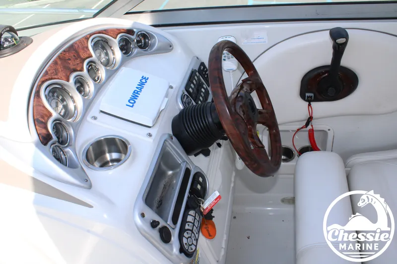 Slide: The Image of The image shows the cockpit of a 2006 Crownline 250 boat with a wood steering wheel and instruments. - 30