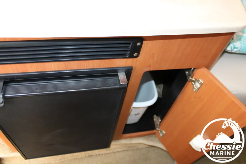 Slide: The Image of The interior view shows a refrigerator and an open cabinet with a trash bin. - 40