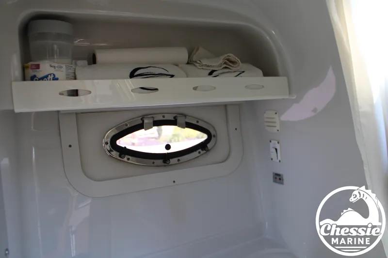 Slide: The Image of A shelf with towels and paper rolls above an oval window in a boat. - 45